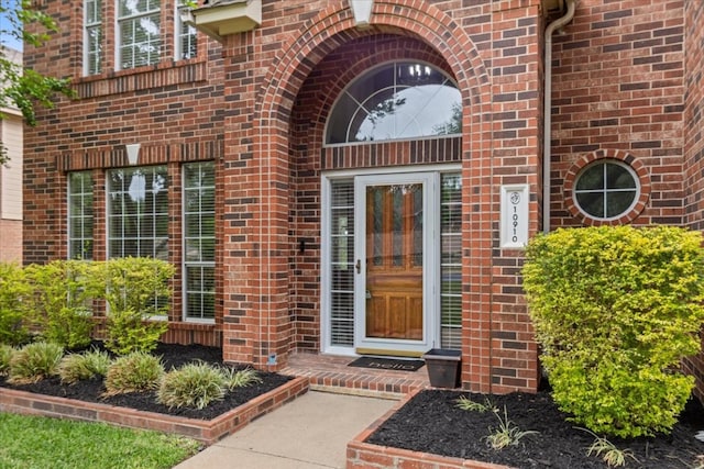 doorway to property featuring brick siding