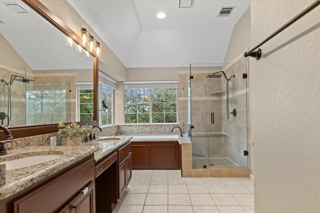 full bath with a sink, a shower stall, vaulted ceiling, and tile patterned floors