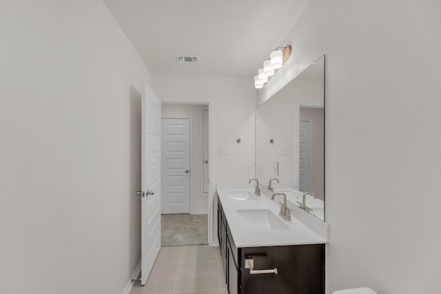 bathroom with double vanity, visible vents, a sink, and tile patterned flooring