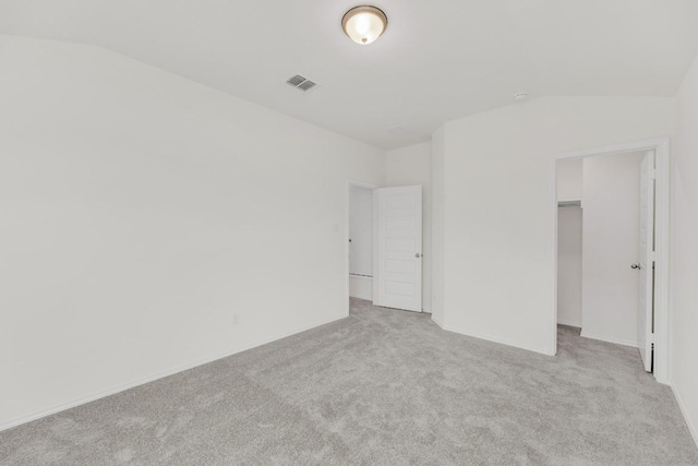 unfurnished bedroom with carpet flooring, visible vents, and vaulted ceiling