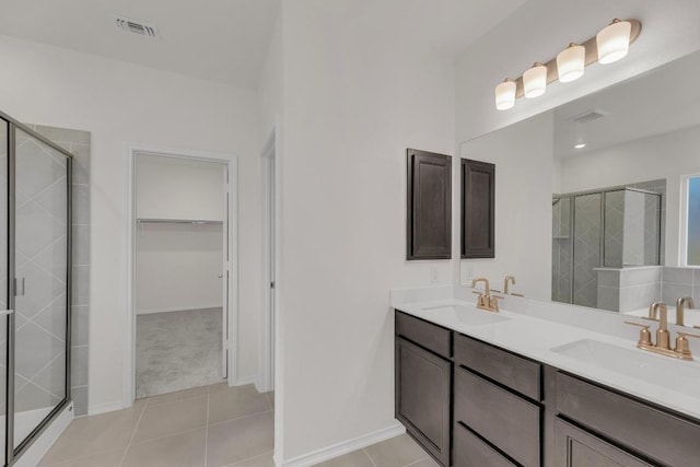 bathroom featuring visible vents, a sink, and a stall shower