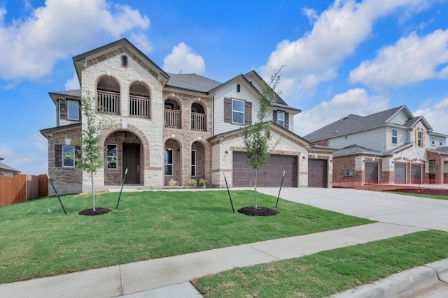 view of front of home with fence, a front lawn, stone siding, concrete driveway, and a balcony