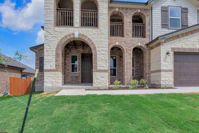 view of front of house featuring a garage, fence, stone siding, and a front yard