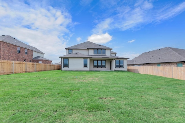 rear view of property with a lawn and a fenced backyard