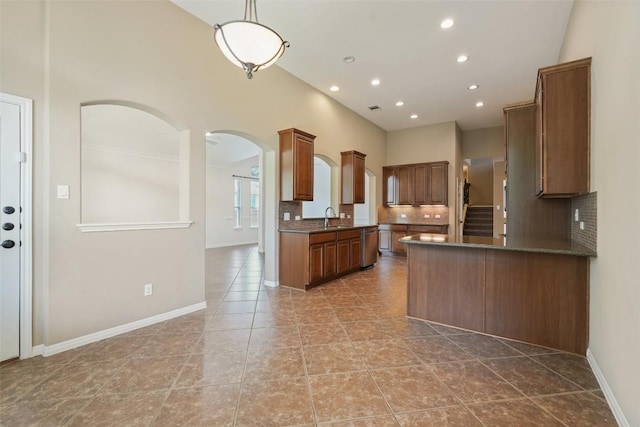 2213 Settlers Park Loop, Round Rock, TX 78665 - kitchen featuring arched walkways, a sink, dark countertops, tasteful backsplash, and recessed lighting