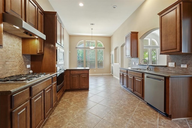 2213 Settlers Park Loop, Round Rock, TX 78665 - kitchen featuring stainless steel appliances, arched walkways, under cabinet range hood, a sink, and dark countertops