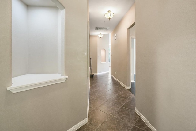 2213 Settlers Park Loop, Round Rock, TX 78665 - hall featuring dark tile patterned floors, baseboards, and arched walkways