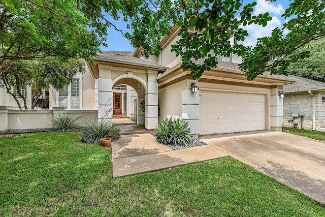 view of front facade with stucco siding, driveway, and a front yard