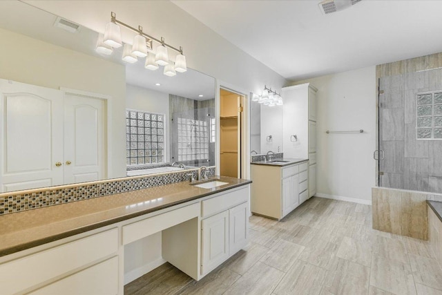 bathroom with a stall shower, visible vents, and vanity