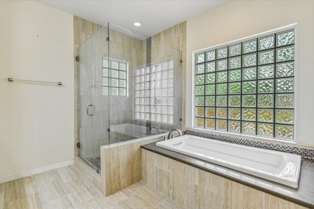 full bathroom with tile patterned floors, a healthy amount of sunlight, a shower stall, and a bath