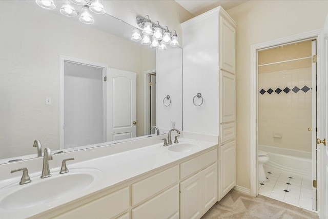 full bathroom featuring toilet, double vanity, a sink, and tile patterned flooring