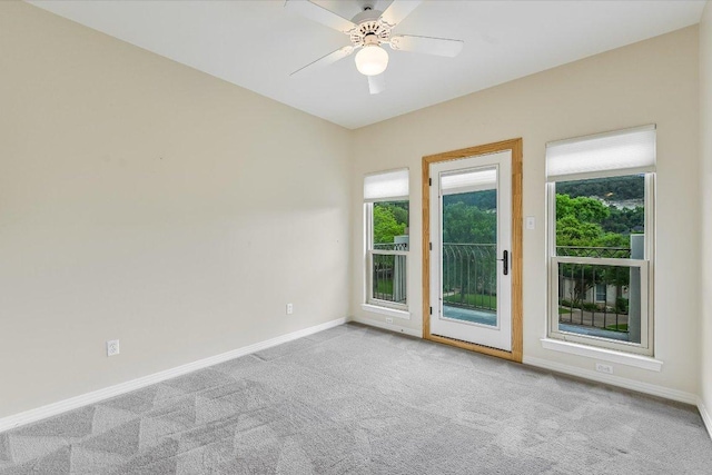 carpeted empty room featuring a ceiling fan and baseboards