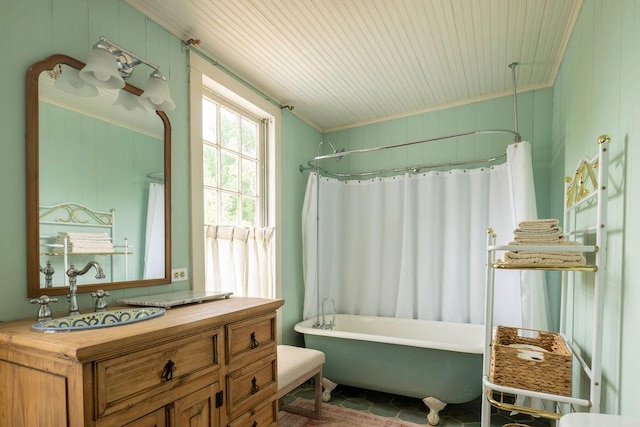 bathroom featuring a freestanding tub, a shower with shower curtain, crown molding, and vanity
