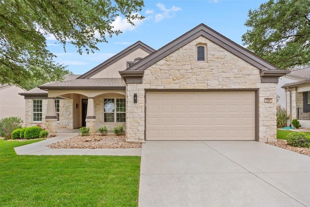 204 San Saba Dr, Georgetown, TX 78633 - view of front of house featuring an attached garage, a front lawn, stone siding, and concrete driveway