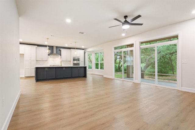 204 San Saba Dr, Georgetown, TX 78633 - unfurnished living room with light wood-style floors, baseboards, a ceiling fan, and recessed lighting