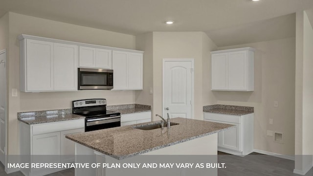 kitchen featuring light stone counters, a sink, appliances with stainless steel finishes, and white cabinetry