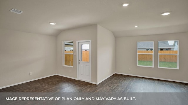 empty room with lofted ceiling, visible vents, baseboards, recessed lighting, and dark wood-type flooring