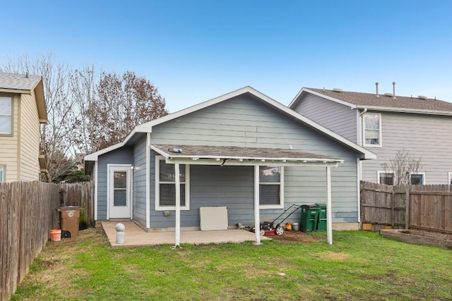 rear view of property with a yard, a patio, and a fenced backyard