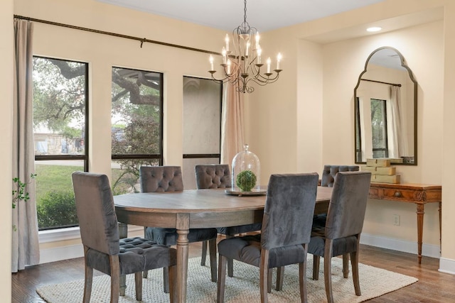 dining room with a chandelier, wood finished floors, and baseboards