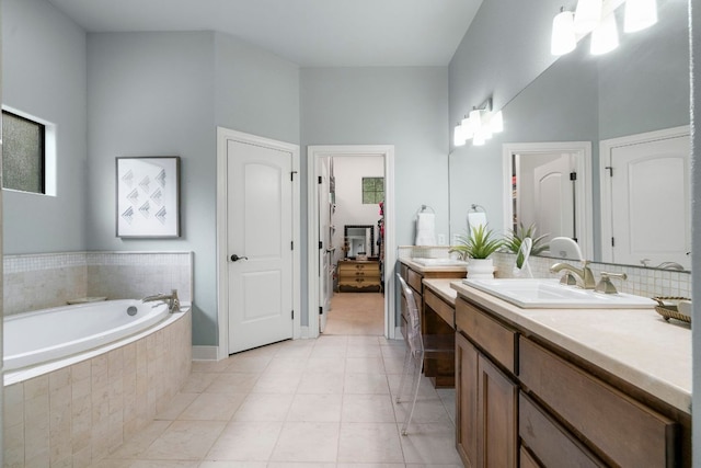 ensuite bathroom featuring a garden tub, vanity, ensuite bath, and tile patterned flooring