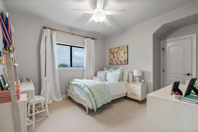 bedroom with a ceiling fan and light carpet