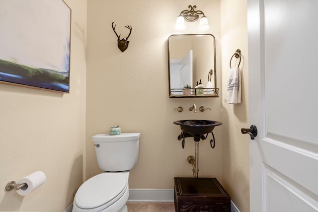 bathroom with toilet and tile patterned flooring