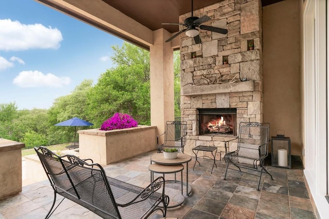 view of patio / terrace with an outdoor stone fireplace and ceiling fan