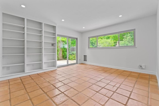 spare room with baseboards, recessed lighting, and built in shelves