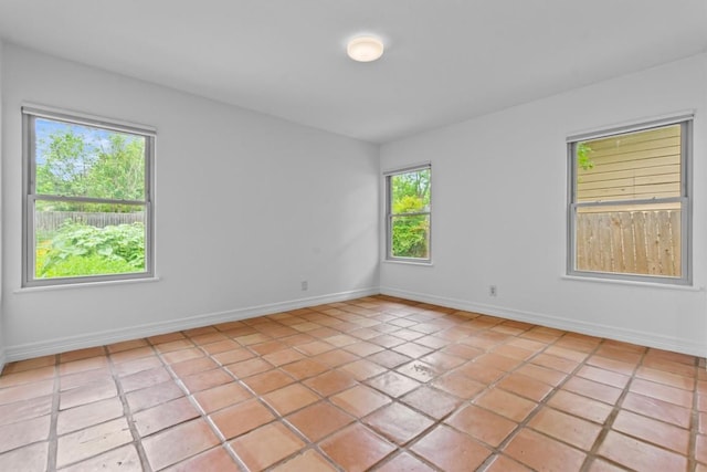empty room with baseboards and light tile patterned floors