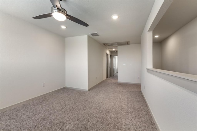 spare room featuring recessed lighting, attic access, ceiling fan, and light colored carpet