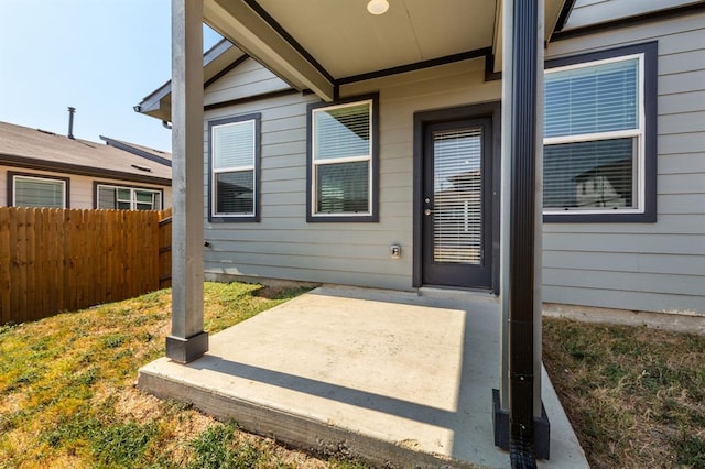property entrance featuring fence and a patio area
