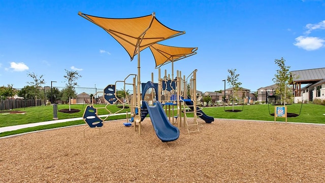 communal playground featuring fence and a yard