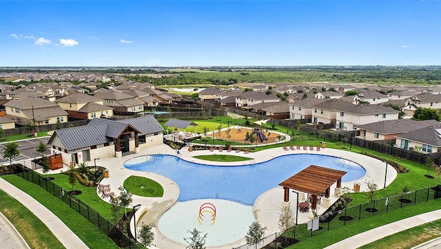 community pool featuring a residential view and fence