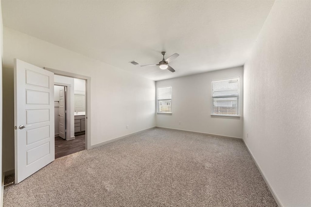 unfurnished bedroom featuring connected bathroom, ceiling fan, visible vents, carpet, and baseboards