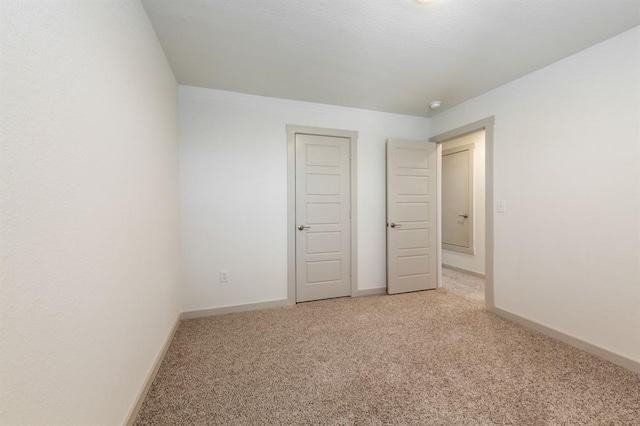 unfurnished bedroom with light carpet and baseboards