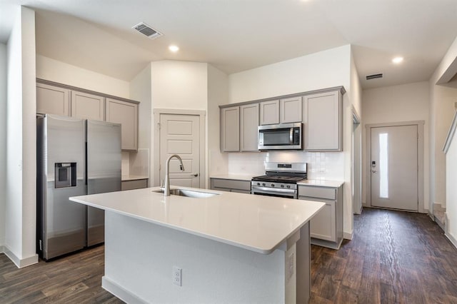 kitchen featuring a sink, visible vents, stainless steel appliances, dark wood-type flooring, and gray cabinets