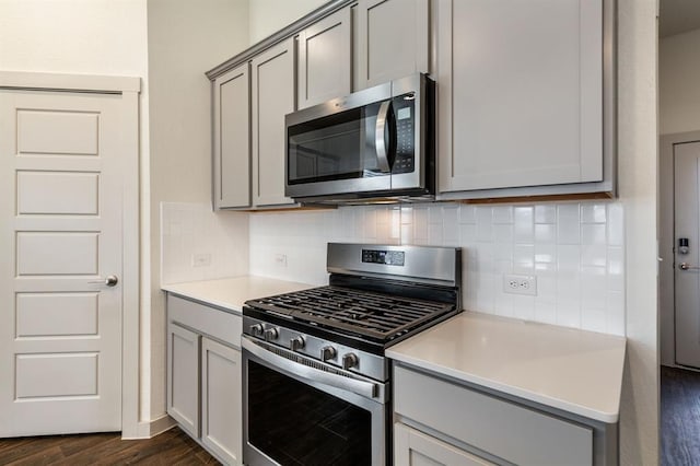 kitchen with appliances with stainless steel finishes, backsplash, and gray cabinets