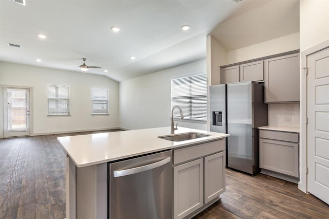 kitchen with vaulted ceiling, stainless steel appliances, gray cabinets, and a sink