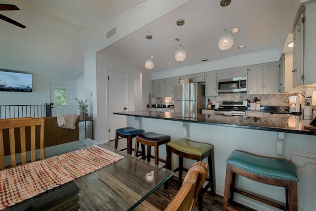 kitchen with visible vents, a sink, appliances with stainless steel finishes, and dark countertops
