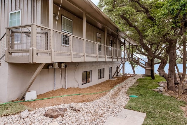 view of building exterior featuring stairs and a water view