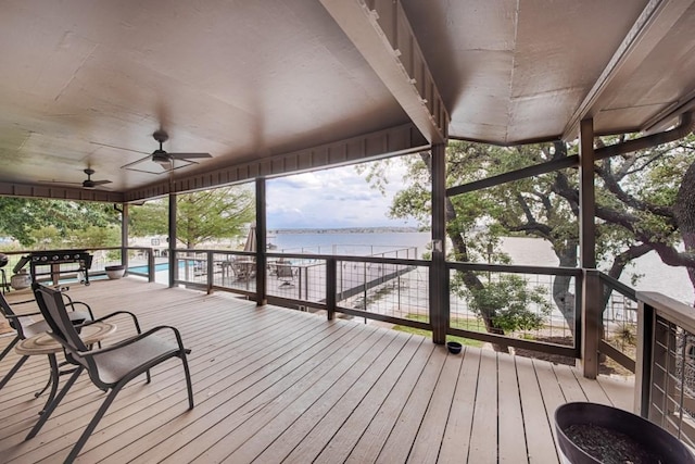 wooden terrace featuring a water view, ceiling fan, and an outdoor pool