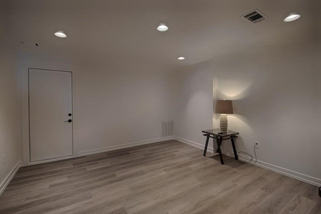 spare room with baseboards, recessed lighting, wood finished floors, and visible vents