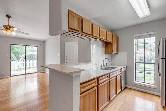 kitchen featuring ceiling fan, stainless steel appliances, light wood-type flooring, and a sink