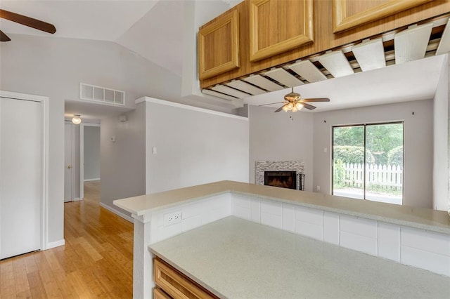 kitchen with light wood-style flooring, ceiling fan, light countertops, and visible vents