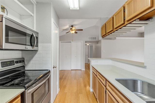 kitchen with visible vents, stainless steel appliances, light countertops, light wood-style floors, and a ceiling fan