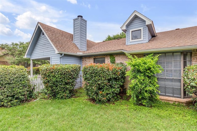 view of property exterior featuring a chimney, fence, a shingled roof, and a yard