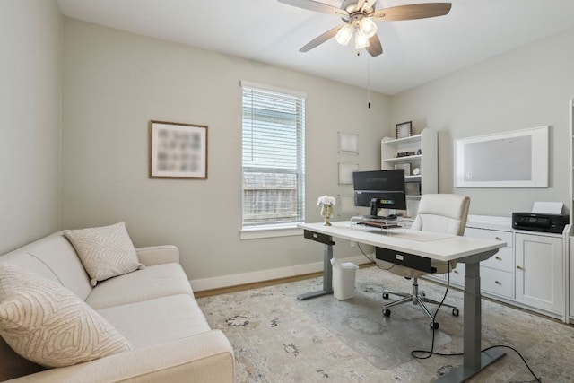 office area with ceiling fan, baseboards, and light wood-type flooring