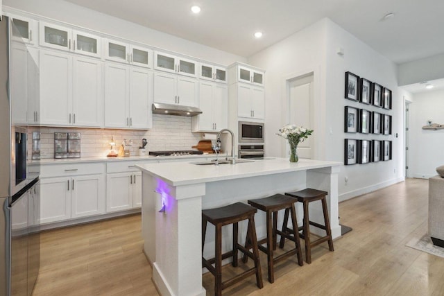 413 Biscayne Bay Bnd, Kyle, TX 78640 - kitchen featuring stainless steel appliances, backsplash, light countertops, light wood-type flooring, and recessed lighting