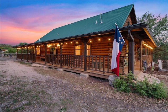exterior space with log veneer siding and metal roof