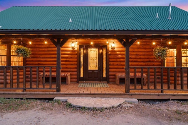 entrance to property with faux log siding and metal roof